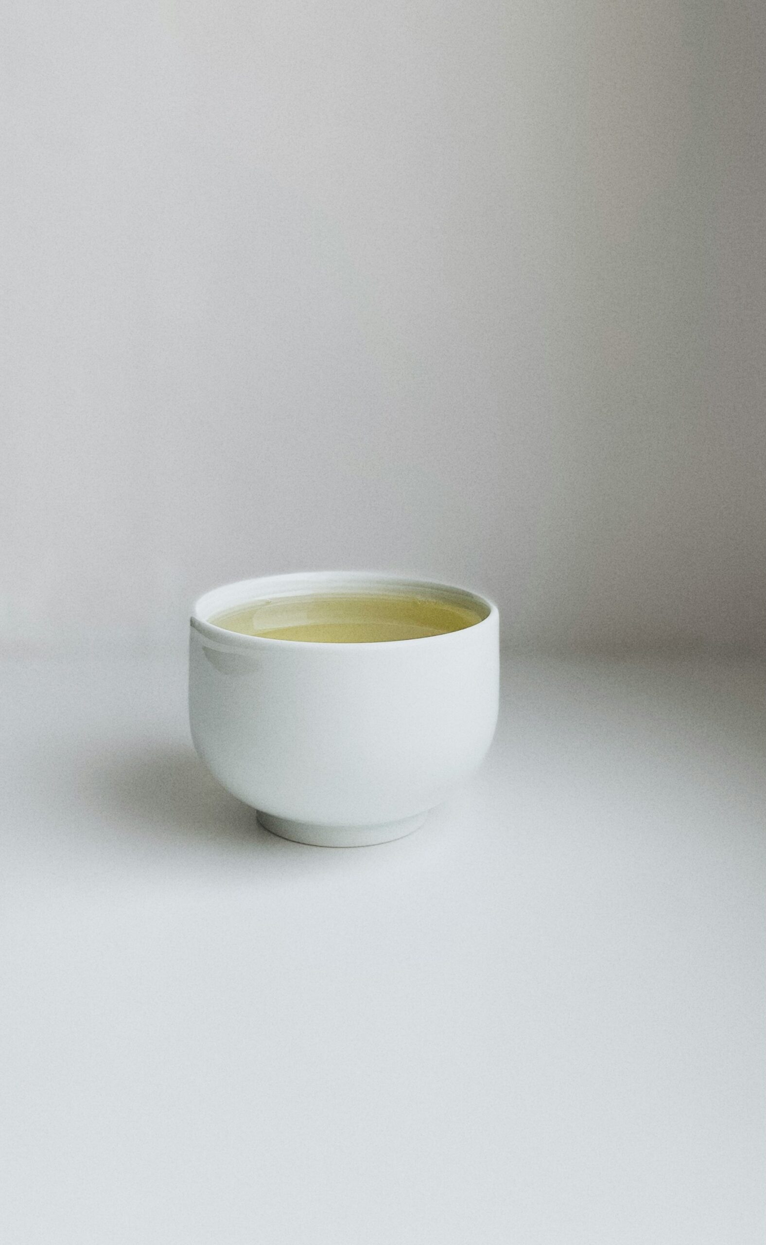 Tasse minimaliste de thé blanc chinois, mettant en valeur la couleur claire et délicate de l'infusion.