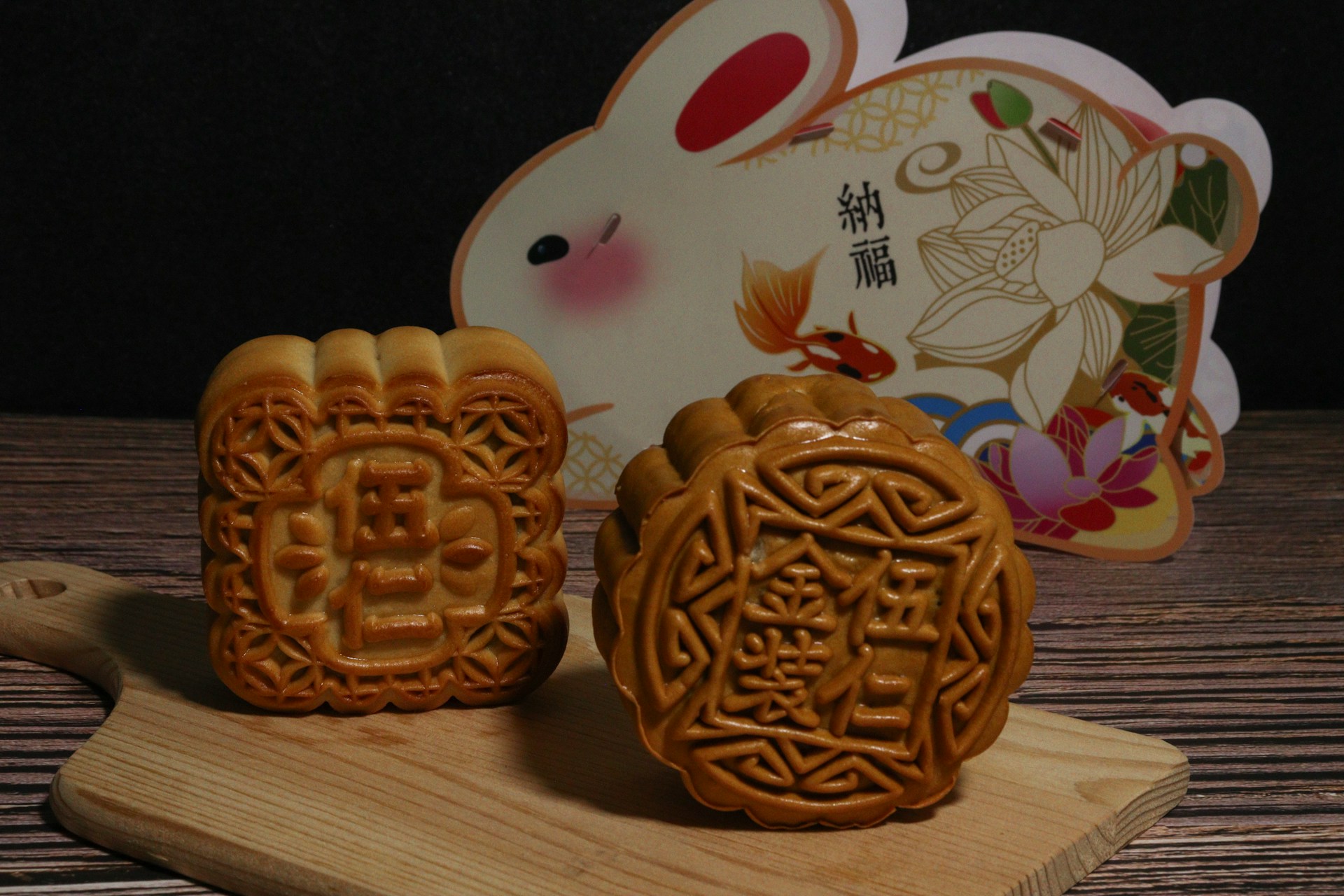 Deux mooncakes traditionnels posés devant le Lapin de Jade, symboles de la réunion et des douceurs du Festival de la Lune.