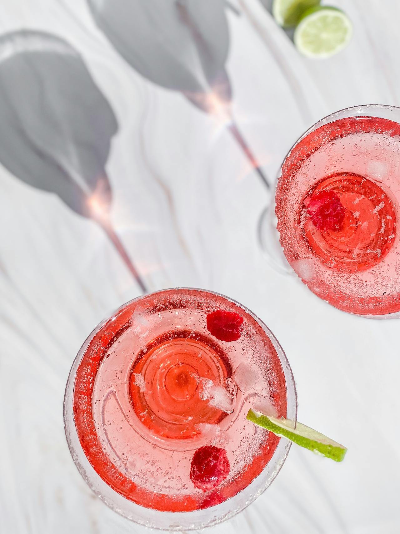 Voici une proposition d'alt-text pour votre cocktail thé blanc et framboise, idéale pour souligner la délicatesse et la fraîcheur de cette recette :

Alt-text :

"Un cocktail au thé blanc et aux framboises fraîches, présentant une robe rose pâle élégante, servi avec des glaçons et garni d'une brochette de framboises dans un verre cristallin.