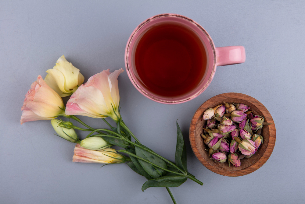 Une tasse de thé chaud servie avec des boutons de rose séchés, mettant en avant les bienfaits du thé floral pour un moment de bien-être quotidien.