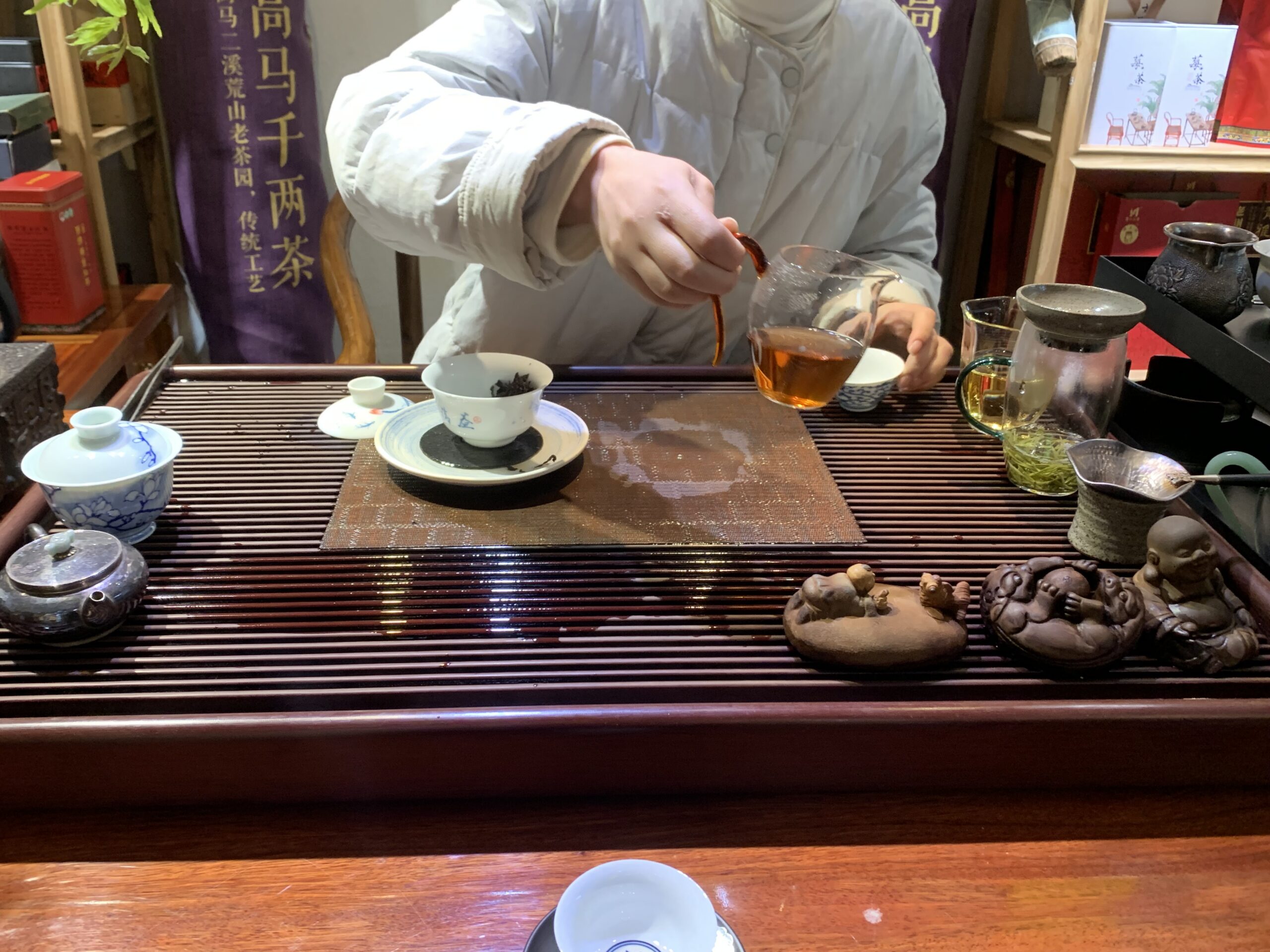 Dégustation de thé à Phoenix Ancient Town (Fenghuang) avec tea pet et mascotte de thé en argile sur un plateau traditionnel, entre Hunan et Guizhou en Chine.