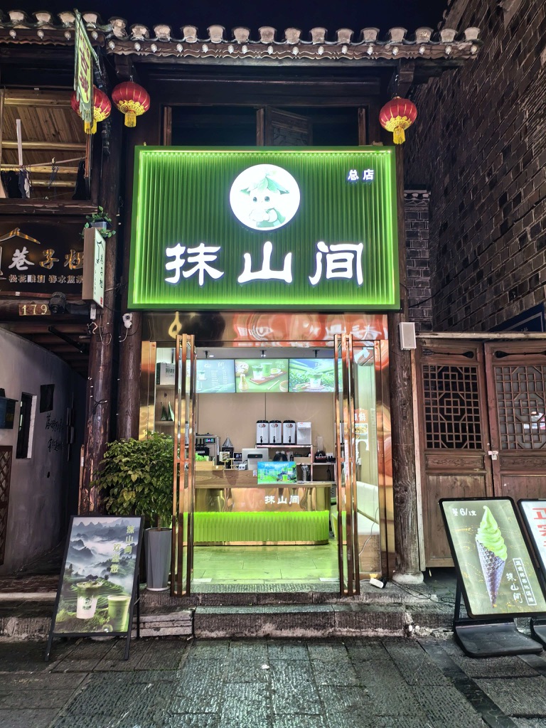 Façade lumineuse d'un magasin moderne à Tongren, la capitale du matcha en Chine, proposant du thé matcha chinois frais, des glaces et des boissons artisanales à base de matcha.