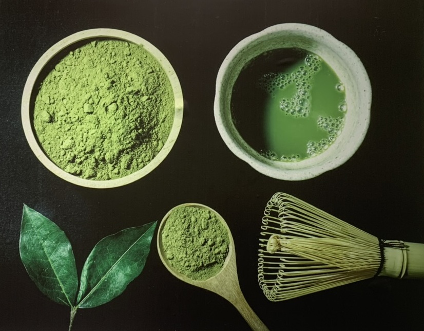Préparation traditionnelle du matcha de Guizhou à Tongren, Chine, montrant la poudre de thé vert intense, un bol de thé fouetté, le fouet en bambou (chasen) et des feuilles fraîches.