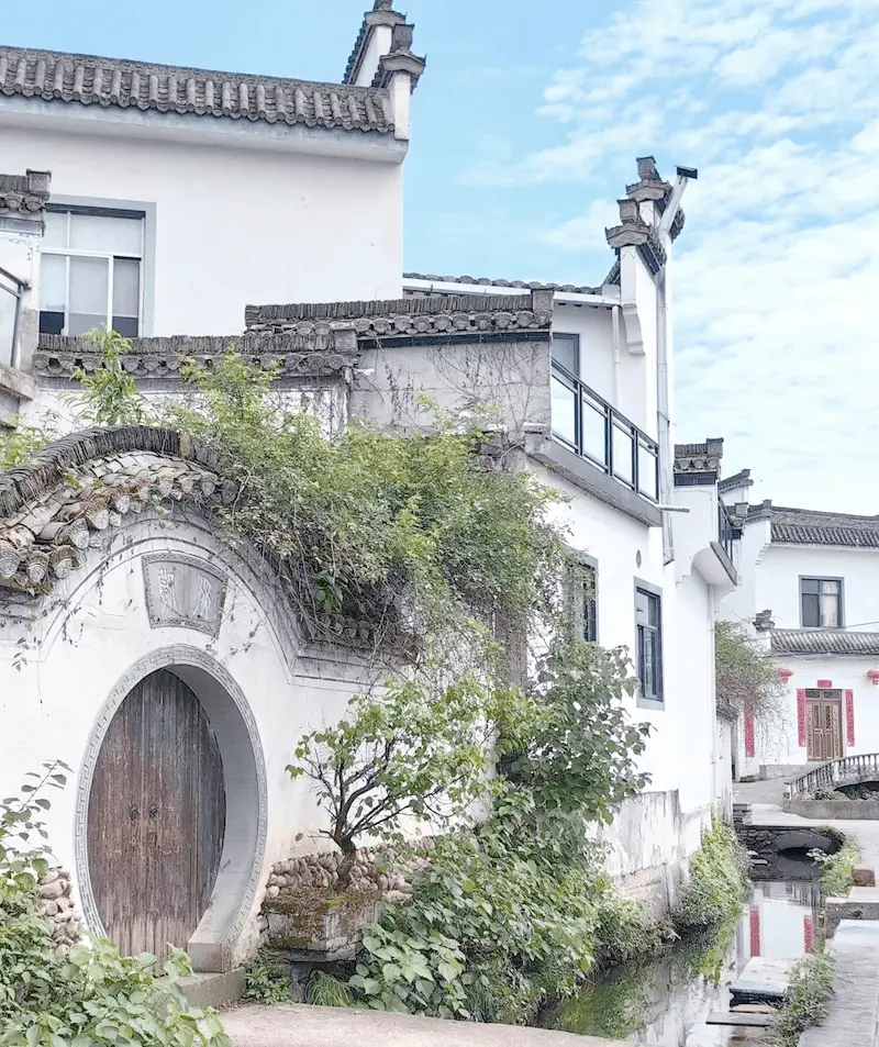 Maison traditionnelle du style Huizhou avec porte lune circulaire au village de Xixinan, à découvrir lors de votre voyage à Qimen.