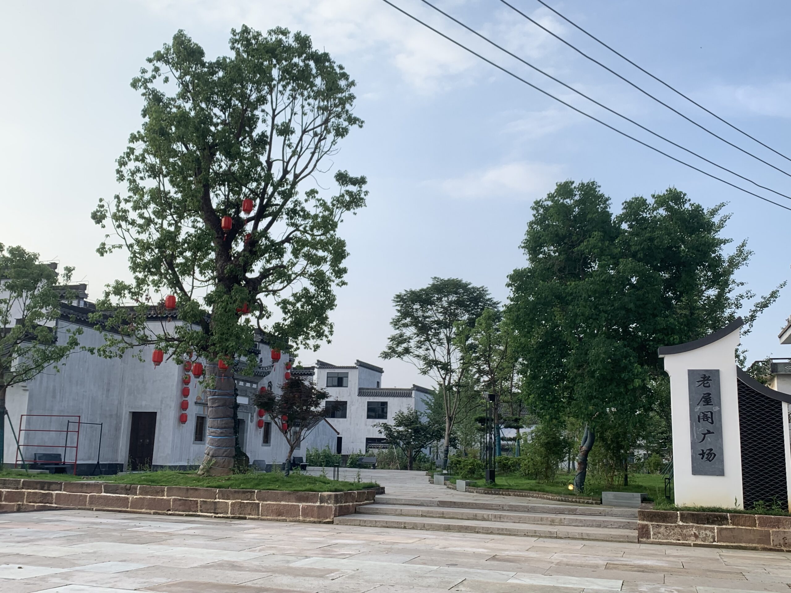 Place du village historique de Xixinan avec grand arbre décoré de lanternes rouges, une étape incontournable lors d'un voyage à Qimen pour visiter Qimen.
